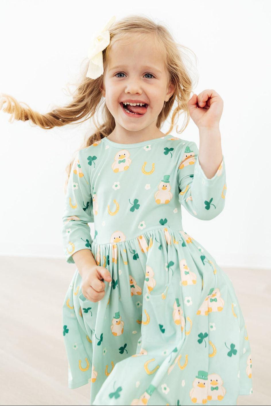 Girl twirling in Lucky Duck 3/4 Sleeve Pocket Twirl Dress in mint green with duck print and full skirt.