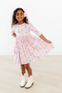 Ribbons & Rodeos 3/4 Sleeve Pocket Twirl Dress in pink with blue boot print, girl twirling.