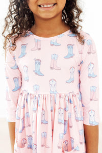 Girl in pink Ribbons & Rodeos 3/4 sleeve twirl dress with boot print and pockets.