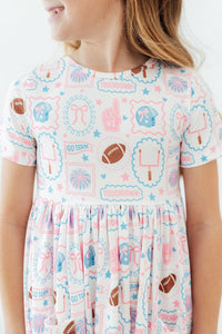 Girl wearing Game Day Girlie short sleeve pocket twirl dress for girls in pastel sports print, twirl skirt.