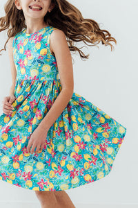 Summer Squeeze Tank Twirl Dress in turquoise tropical floral print worn by a smiling girl twirling.
