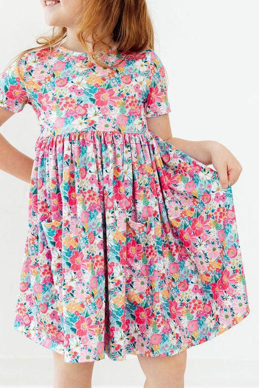 Petal Promises Short Sleeve Pocket Twirl Dress in a bright floral print, twirly skirt, perfect for school and play.