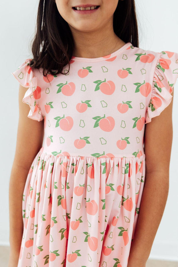 Georgia Peach Flutter Sleeve Twirl Dress in pink peach print with flutter sleeves and twirl skirt.