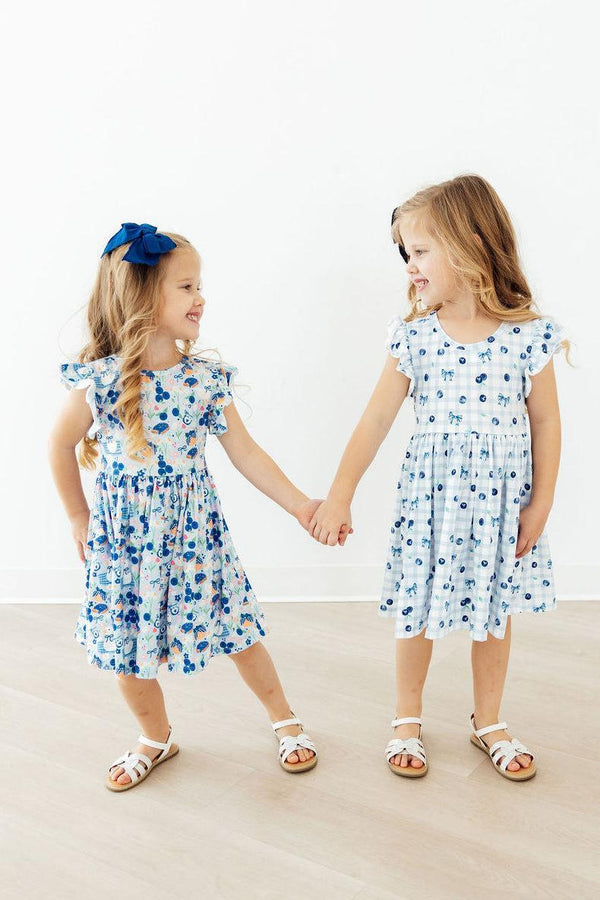 Close-up of the Blueberry Picnic Flutter Sleeve Girls Twirl Dress, highlighting the scoop back and twirl-ready skirt, ideal for everyday play.