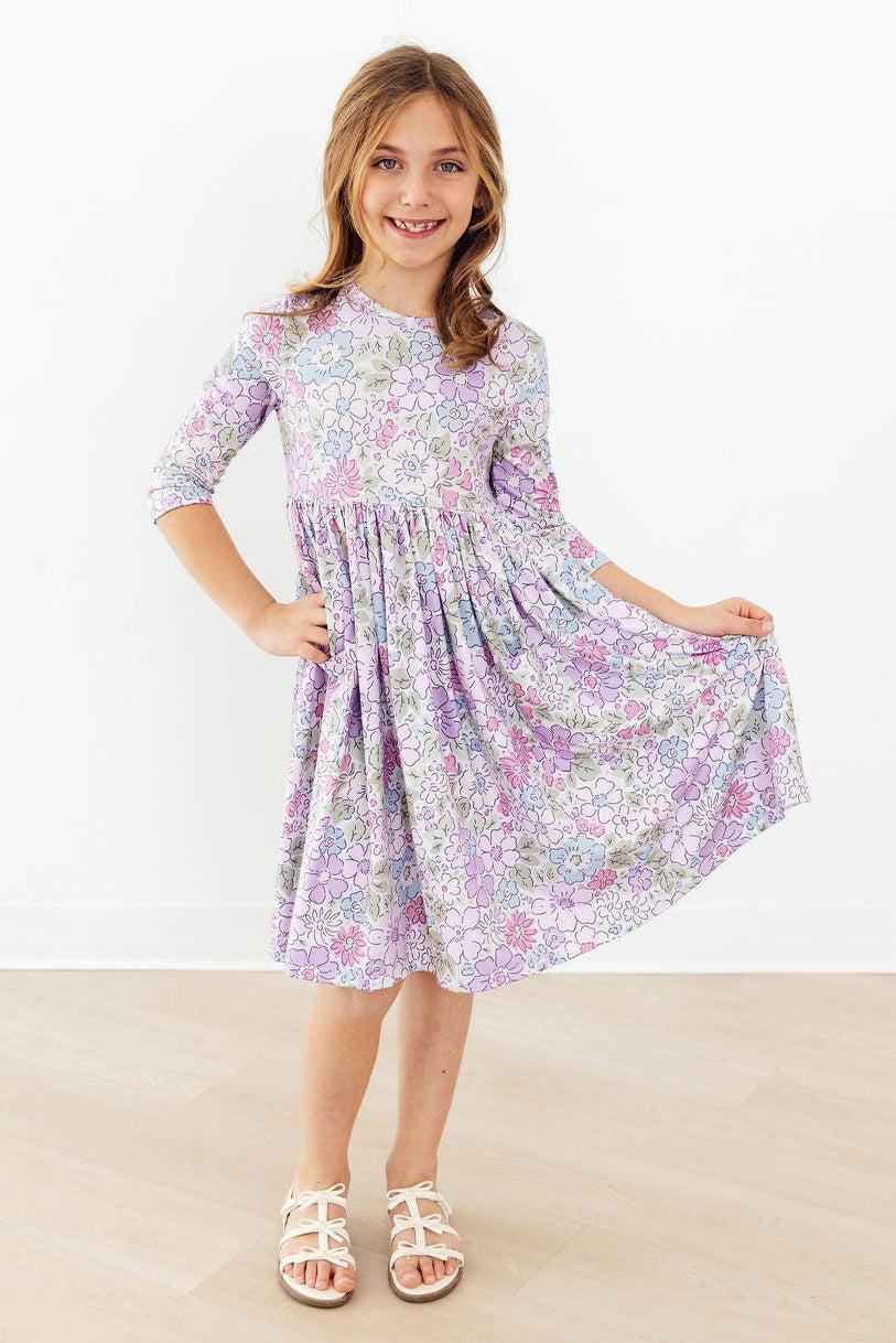 Girl wearing Spring Gardens 3/4 Sleeve Pocket Twirl Dress with pastel floral print, twirling.