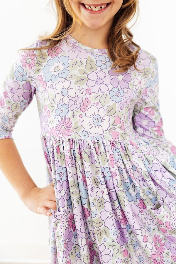Spring Gardens 3/4 sleeve pocket twirl dress in pastel florals with scoop back on a smiling girl.