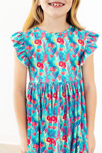 Little girl in Lovely Llamas Flutter Sleeve Twirl Dress, turquoise print with llamas and bright pink flowers.