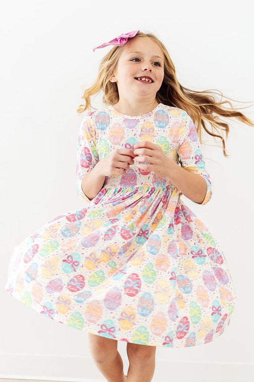 Egg-stra Cute 3/4 sleeve pocket twirl dress on a smiling girl in pastel bow-print fabric.