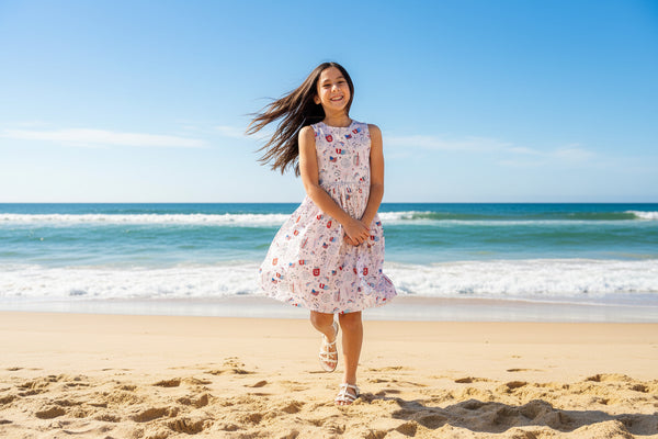 Girl wearing Born in the USA Tank Twirl Dress twirls in patriotic print, full skirt, scoop-back neckline.