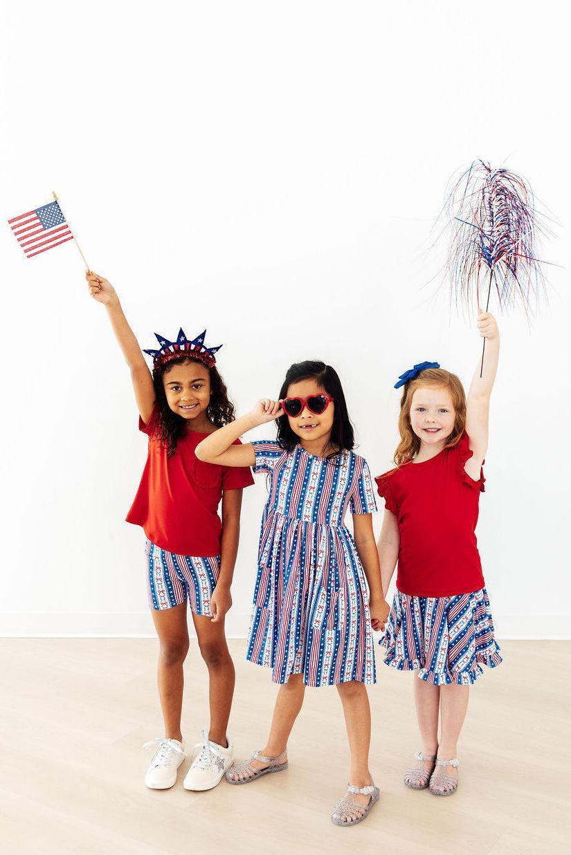 All-American Girl Short Sleeve Pocket Twirl Dress worn by three kids in patriotic red, white, and blue outfits.