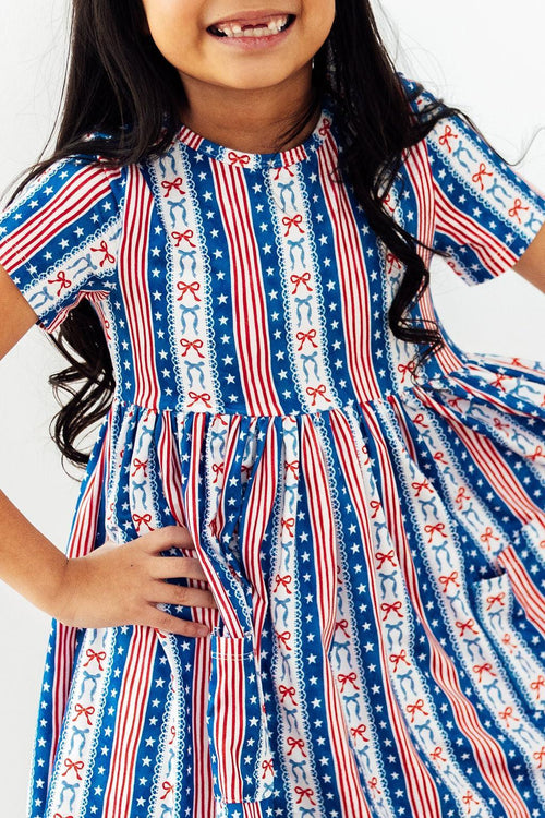 All-American Girl short sleeve pocket twirl dress in patriotic red, white, and blue stripes with pockets.