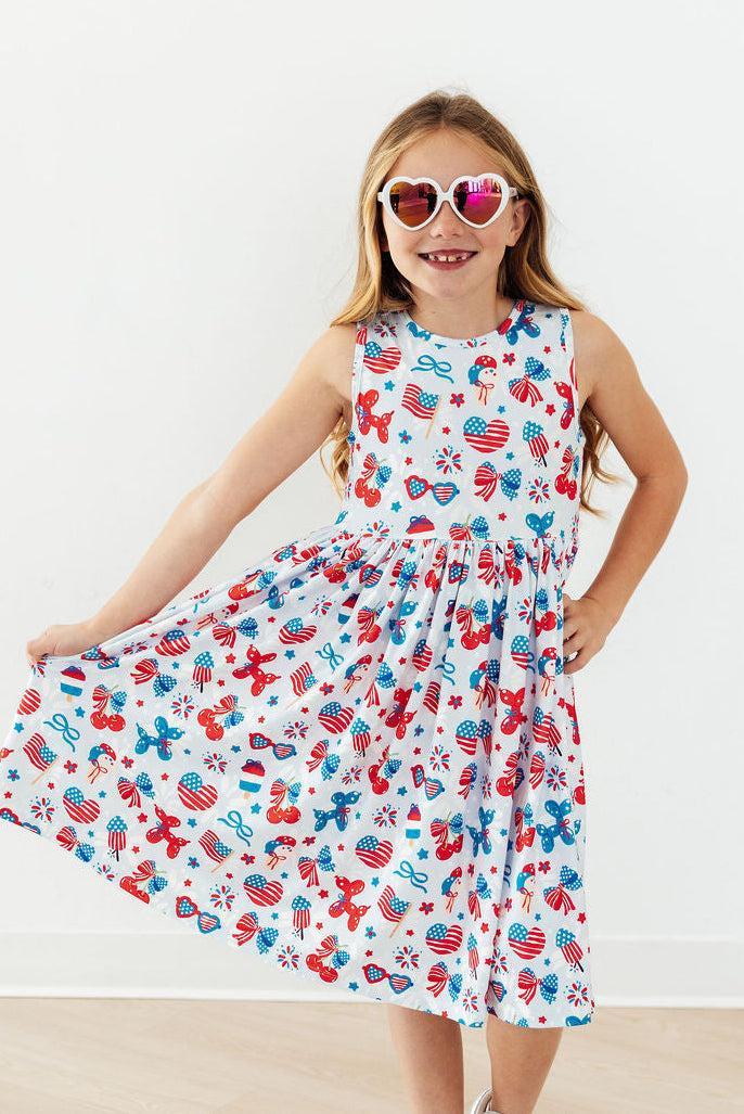 Girl wearing Little Miss Liberty Tank Twirl Dress with scoop back, ballet neckline, full twirl skirt.