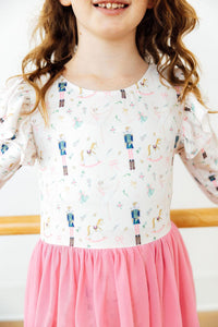 Children's long sleeve Christmas leotard with nutcracker and ballerina print, paired with a pink tulle skirt.