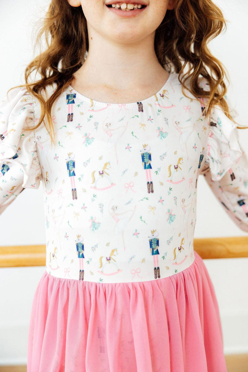 Children's long sleeve Christmas leotard with nutcracker and ballerina print, paired with a pink tulle skirt.