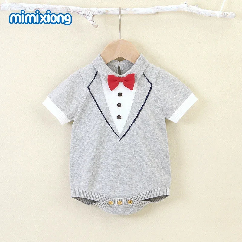 Gray baby boy knit romper with short sleeves, tuxedo design, and red bow tie for infants