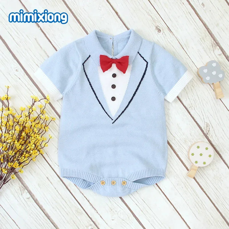 Light blue baby boy knit romper with red bow tie and tuxedo design for infants