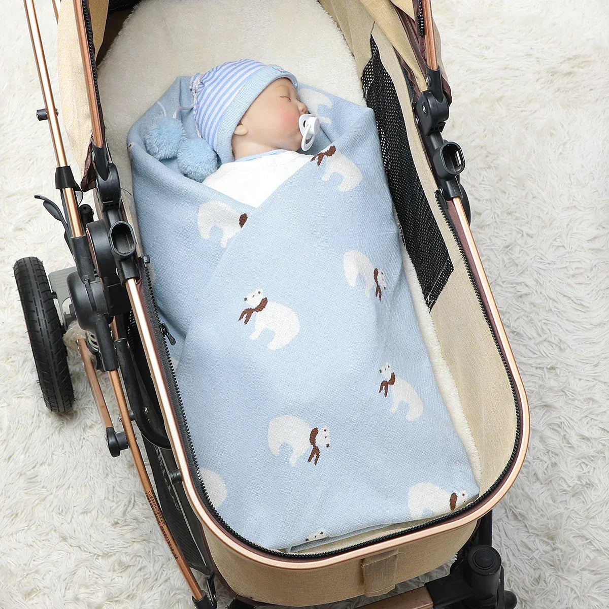 Blue cotton baby blanket with white polar bear print wrapped around newborn in stroller
