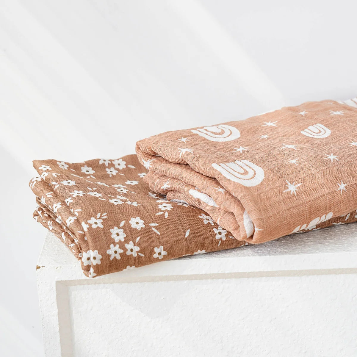 Brown muslin swaddle blankets for babies with white floral and rainbow star prints