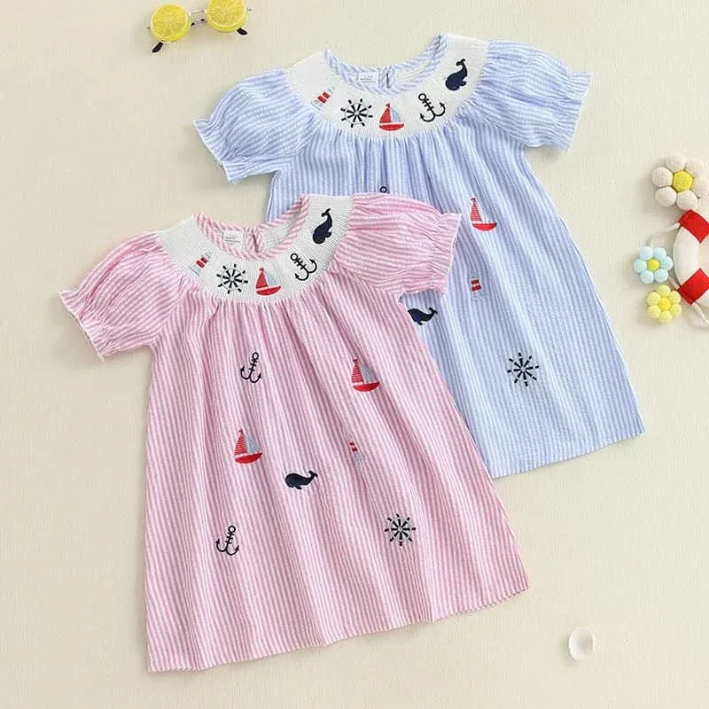 Two nautical smocked dresses for girls in pink and blue with embroidered sea motifs for toddlers