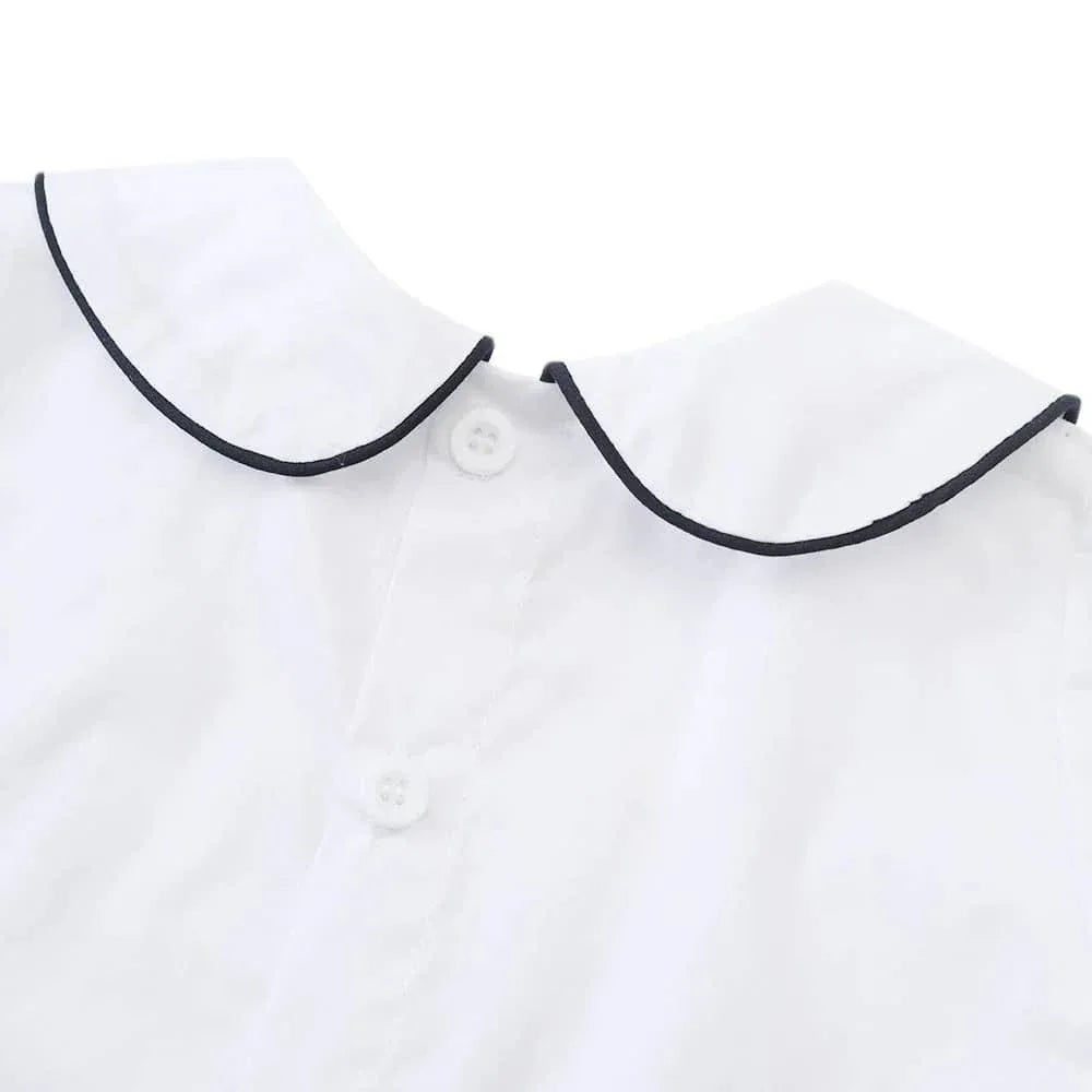 Close-up of white nautical smocked romper for baby boys with navy trim collar in size newborn