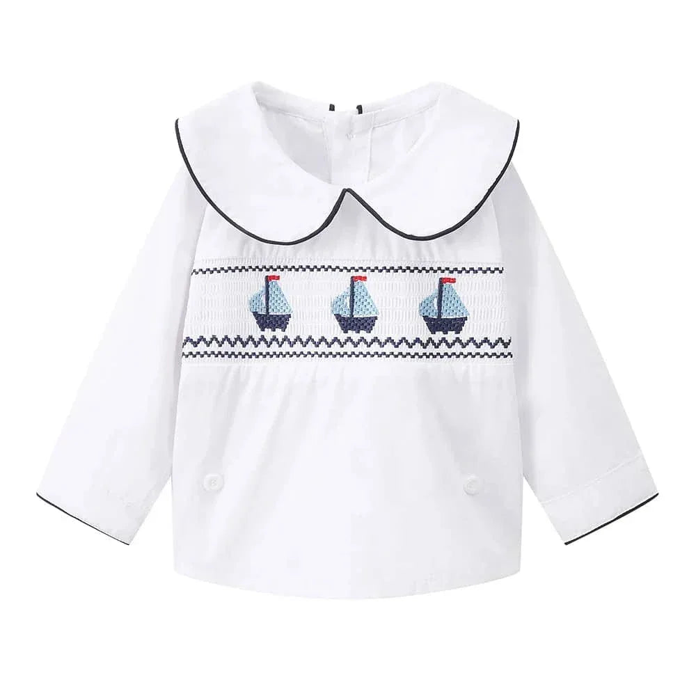 white nautical smocked romper for baby boys with blue sailboat embroidery and black trim collar