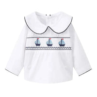 white nautical smocked romper for baby boys with blue sailboat embroidery and black trim collar