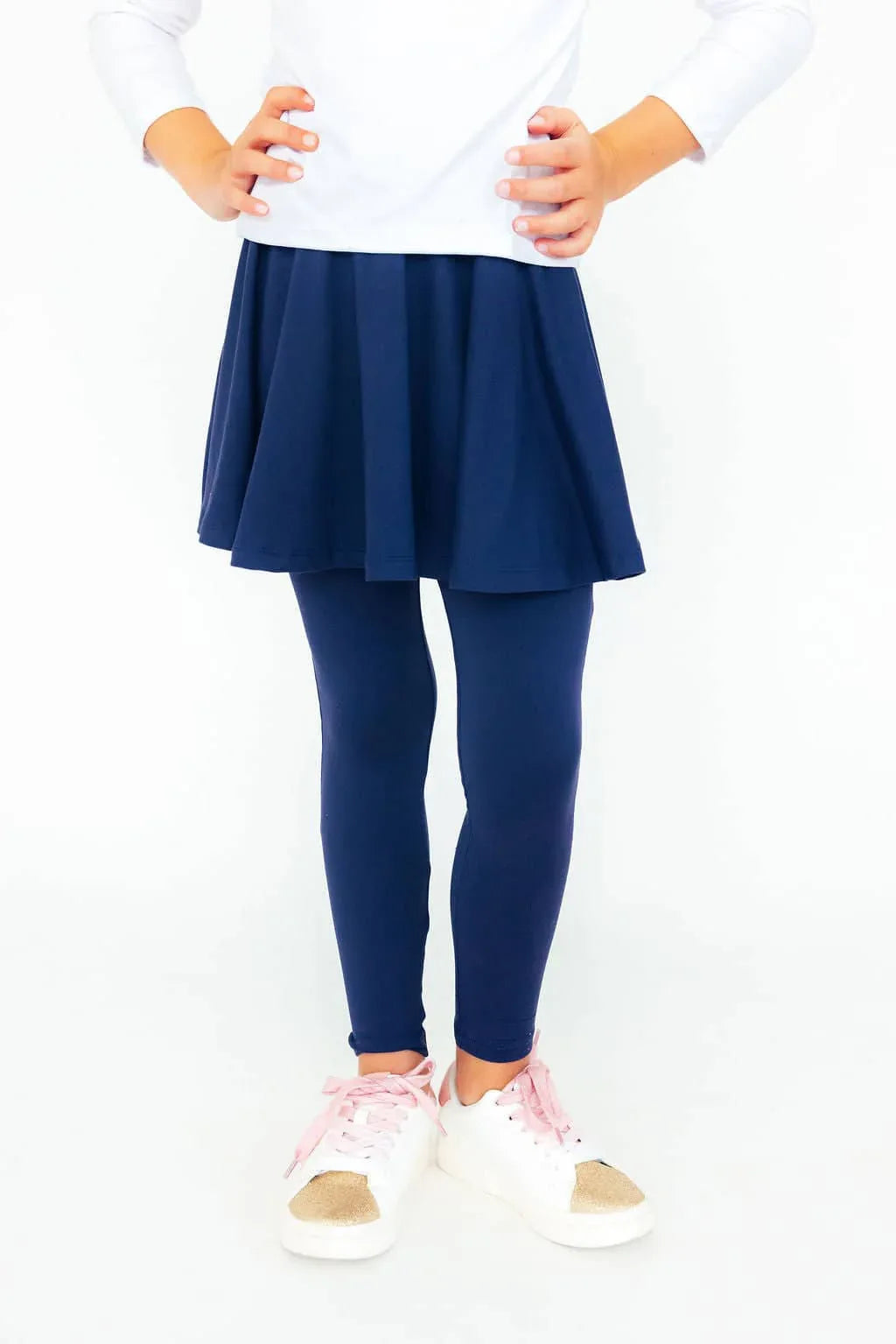 girl wearing navy twirl skegging for girls with pink shoes standing with hands on hips