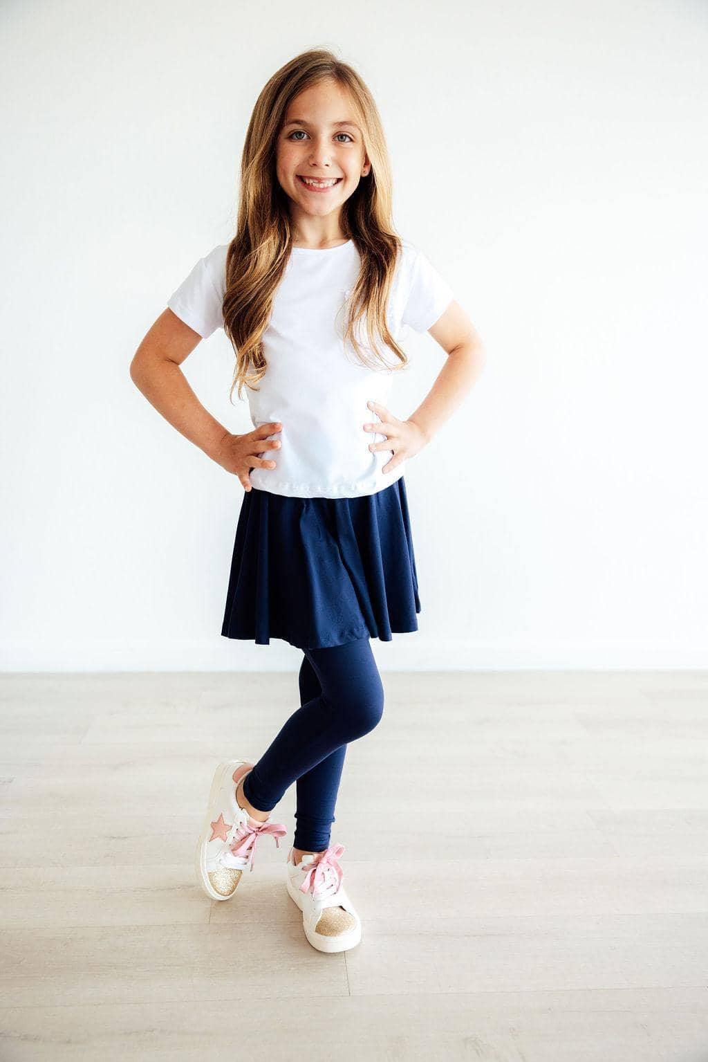 girl wearing navy twirl skegging for girls standing with hands on hips and smiling