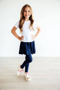girl wearing navy twirl skegging for girls standing with hands on hips and smiling