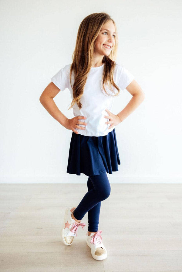girl wearing navy twirl skegging for girls with white t-shirt standing with hands on hips