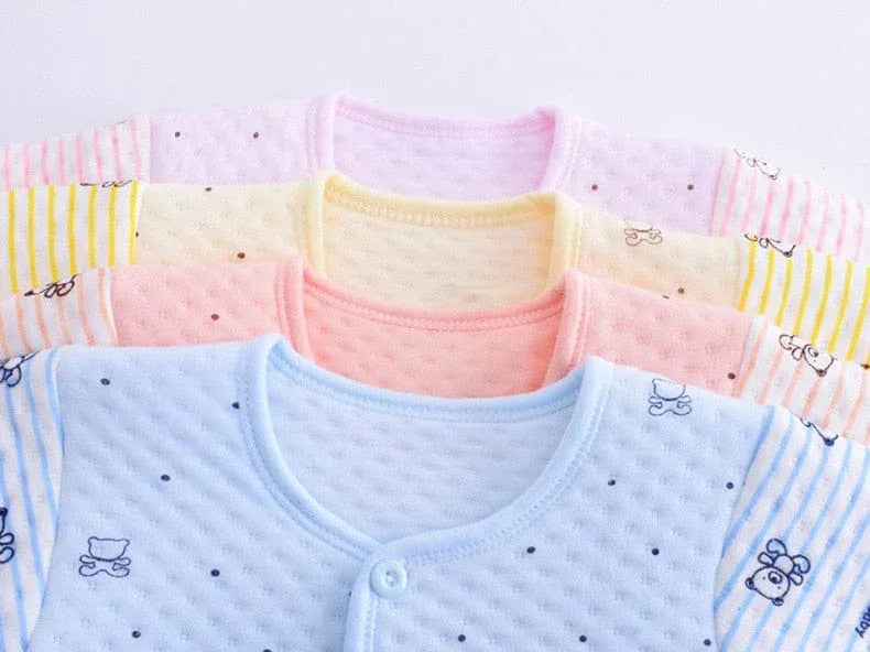 Newborn baby layette set with pink, yellow, peach, and blue long sleeve tops featuring bear and stroller prints