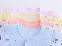Newborn baby layette set with pink, yellow, peach, and blue long sleeve tops featuring bear and stroller prints