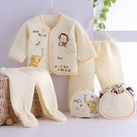 Cream newborn quilted layette set for babies with long sleeve jacket, footed pants, hat, and bib featuring animal embroidery