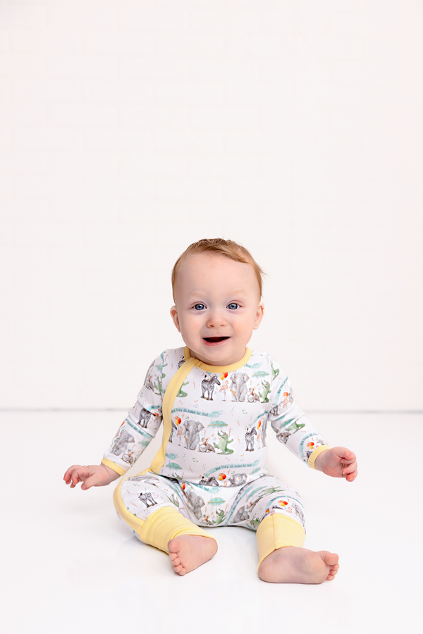 Baby wearing And They All Asked For You organic cotton sleepwear with a cheerful elephant print and yellow trim.