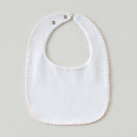 White baby bib with pink hem and snap closures from the Pink Newborn Take Me Home Set.