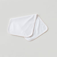 White newborn take me home swaddle blanket with soft baby pink trim for a sweet and elegant hospital outfit.
