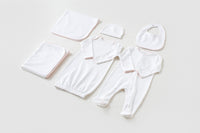 White newborn take me home set with pink trim, including gown, footed pajama, hat, bib, and blankets.