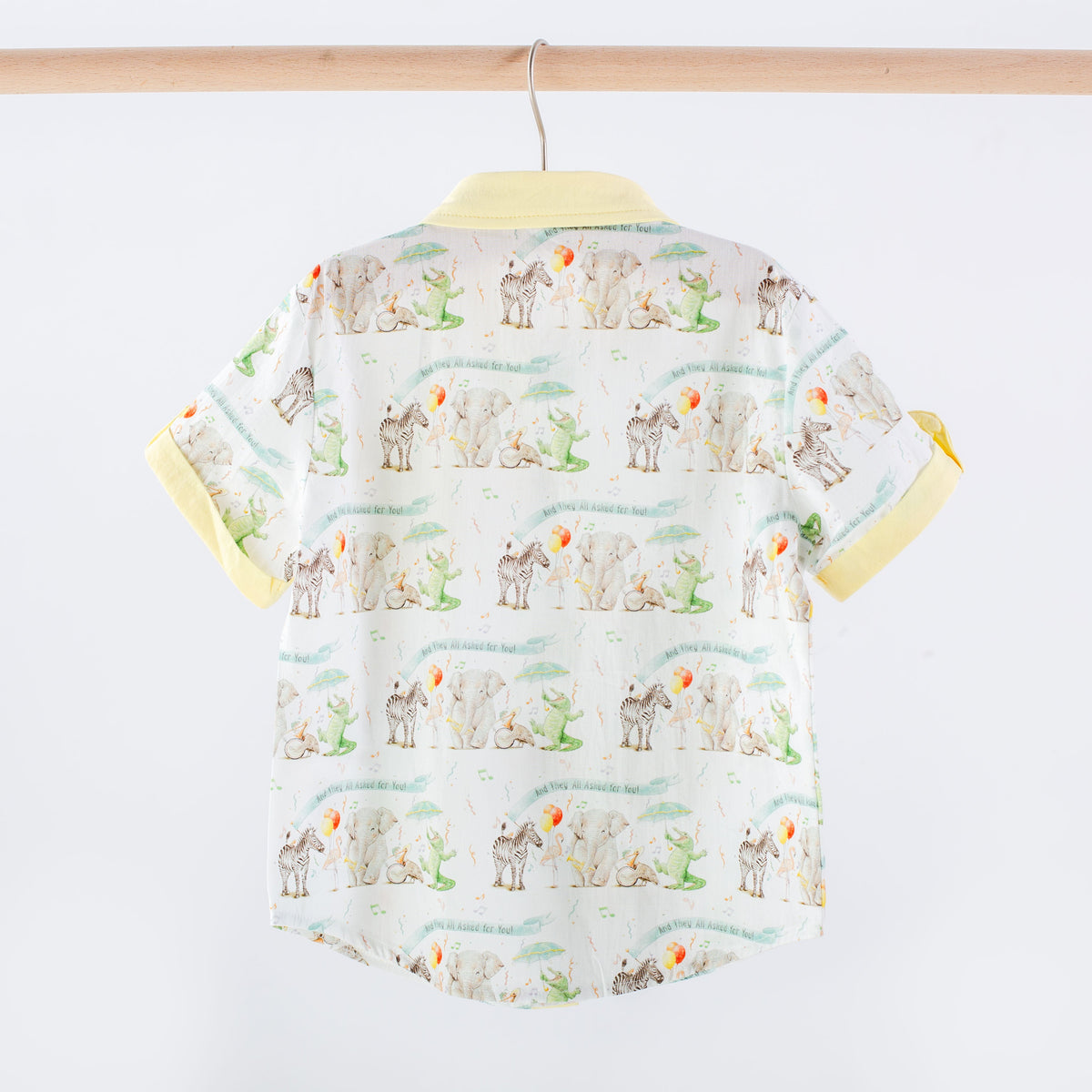 Children's shirt with animal pattern on a hanger against a white background