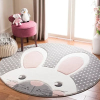 Round gray and white nursery rug with pink bunny ears and polka dots for baby room