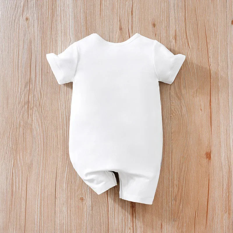 White cotton ocean themed baby romper with short sleeves on wooden background