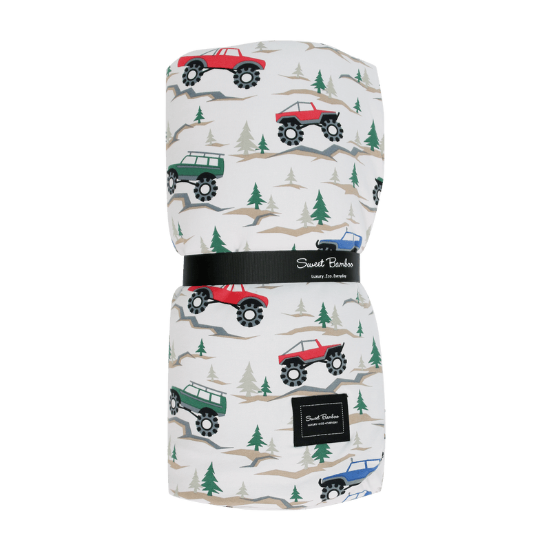 Folded blanket with vehicle pattern on a green background