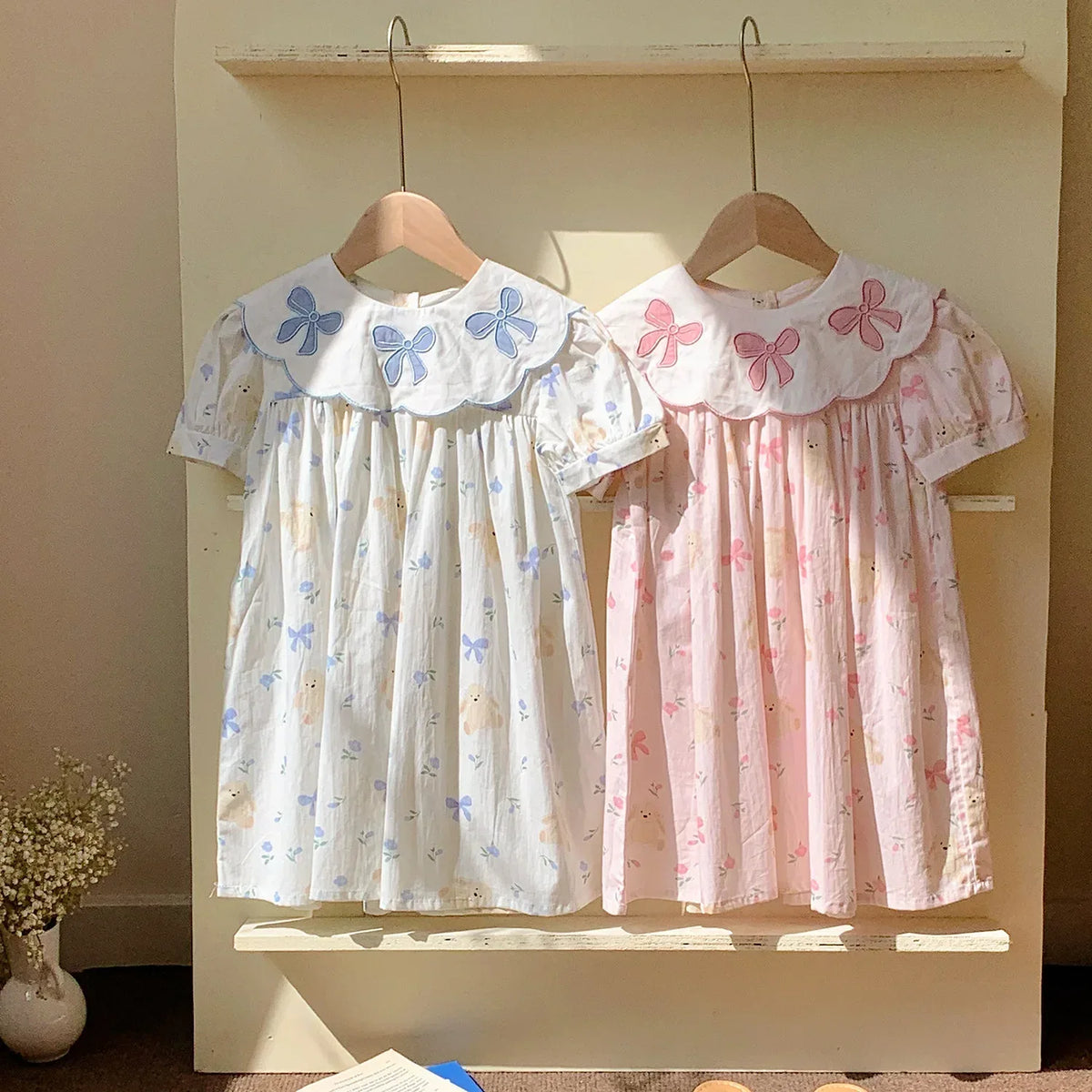 Girls pastel blue and pink party dress with embroidered bows and floral print for toddlers