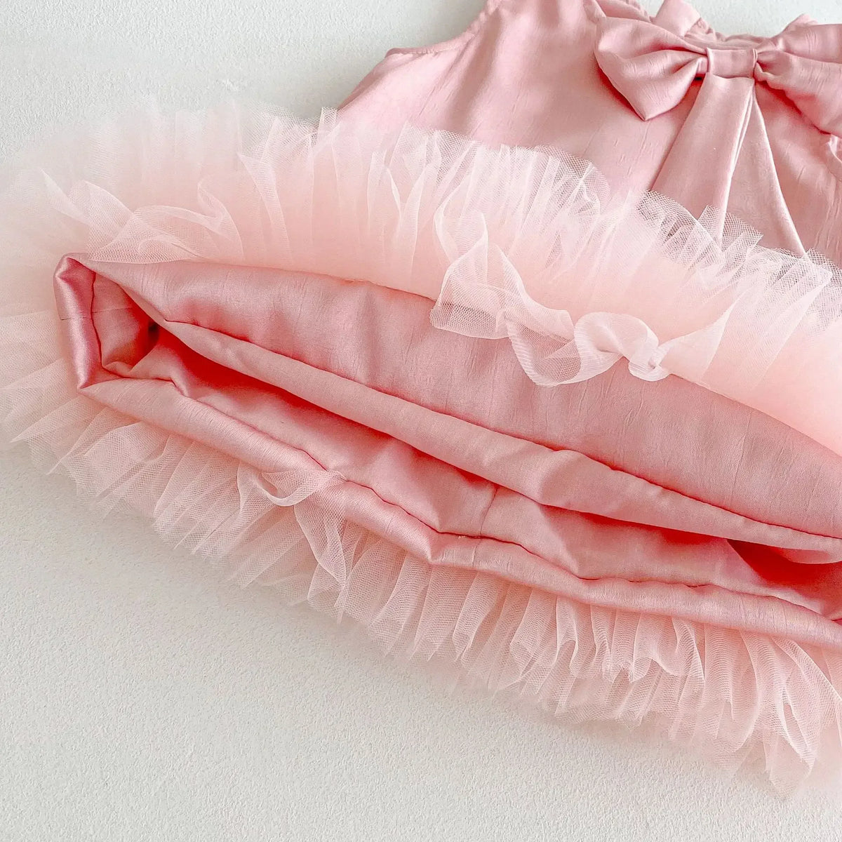 Baby pink party dress with tulle frill trim and bow detail for infants and toddlers
