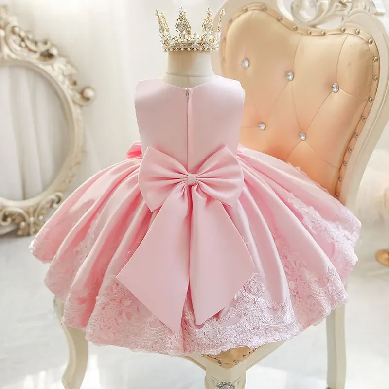 Pink party dress for girls with large bow and lace trim, suitable for toddlers and young kids