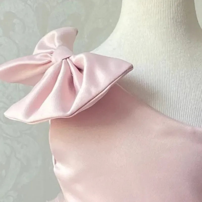 baby pink satin party dress with large bow detail on shoulder for infants