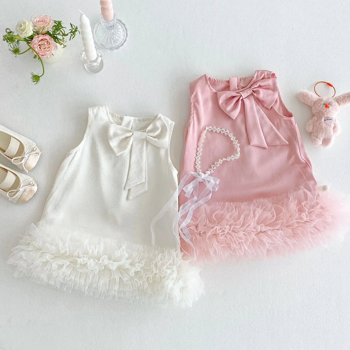White and pink sleeveless baby party dress with large bow and ruffled tulle hem for toddlers