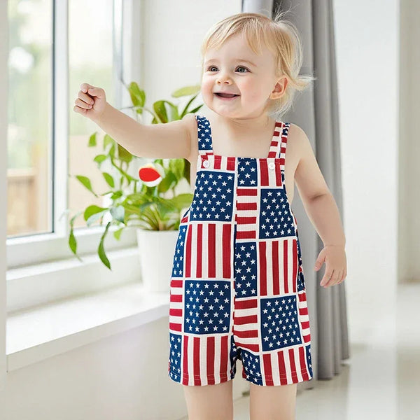 Toddler boy wearing patriotic baby overalls with American flag pattern standing and smiling indoors