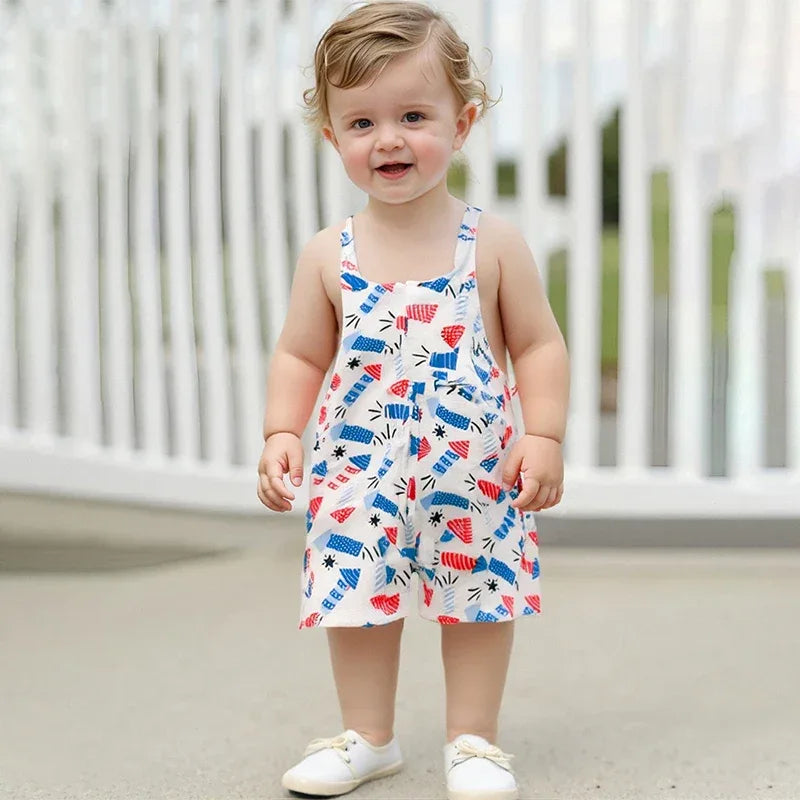 toddler boy wearing patriotic baby overalls with red blue and white star and stripe pattern standing outdoors