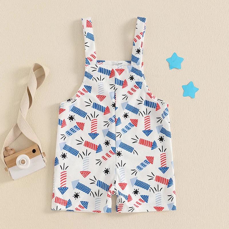baby white patriotic baby overalls with red and blue firework print laid flat with toy camera and blue stars