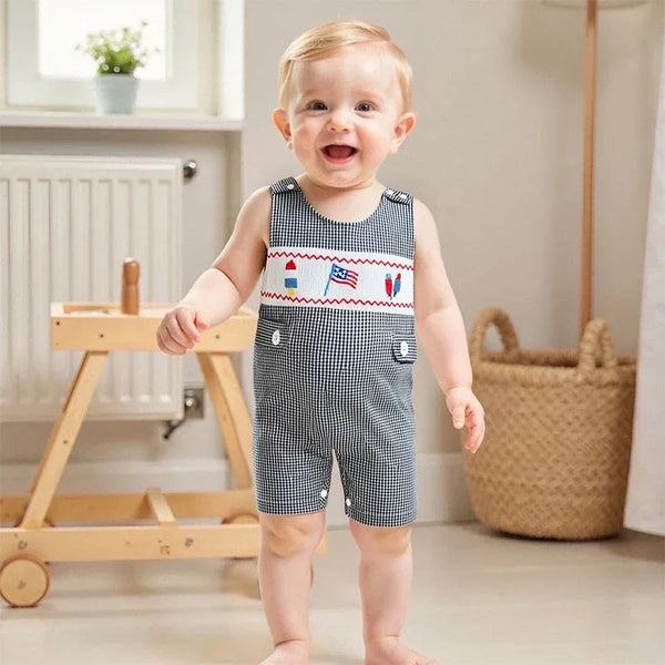 Baby boy wearing a black and white checkered patriotic baby romper with embroidered flags and rockets